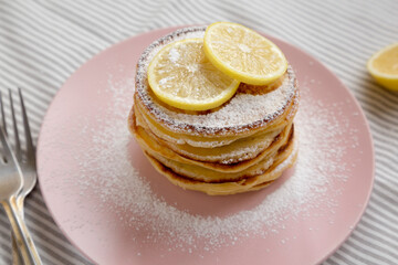 Homemade Lemon Ricotta Pancakes on a pink plate, low angle view. Close-up.