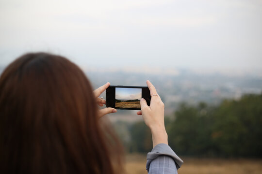 woman taking photo with mobile phone