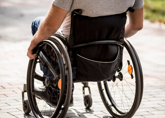 Handicapped man in wheelchair walk at the park alley