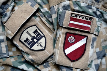 Latvian flag on the military khaki texture background. Latvian flag on army  uniform, military concept