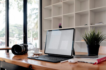 Creative workspace with tablet computer and  gadget on wooden table in co-workspace.