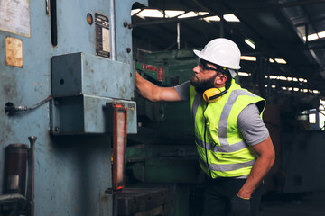 A engineer or technician or worker working with blue print drawing spec about machine part...