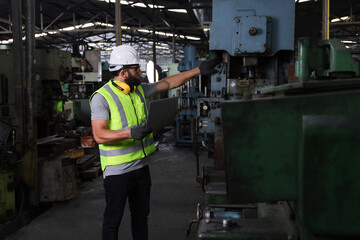 A engineer or technician or worker working with blue print drawing spec about machine part...