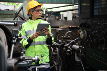 A Engineer woman using tablet or computer for inspect or checking or adjust or operate control the machine in workshop factory, the technician repair or maintenance part or equipment 