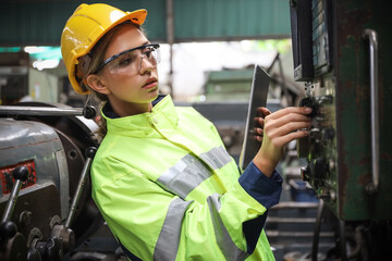 A Engineer woman using tablet or computer for inspect or checking or adjust or operate control the machine in workshop factory, the technician repair or maintenance part or equipment 