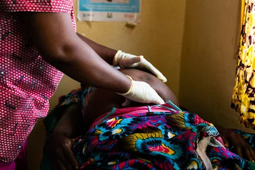 Fotobehang Afrika African woman doctor checking on a pregnant patient  © Belen B Massieu