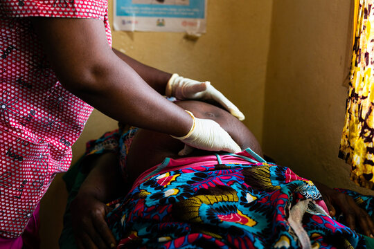 African woman doctor checking on a pregnant patient