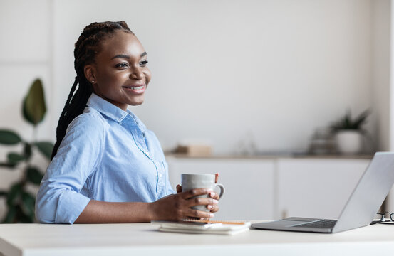 Dreamy Young Black Busines Lady Having Coffee Break At Workplace In Office