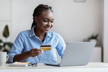 Online Payment. Smiling Black Businesswoman Using Laptop And Credit Card In Office