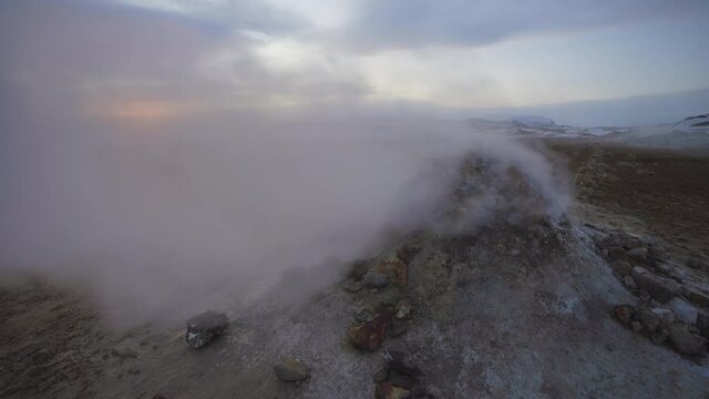 Námaskarð Geothermal Area, North Iceland. Steam coming from an old borehole at sunrise blowing around in strong wind.