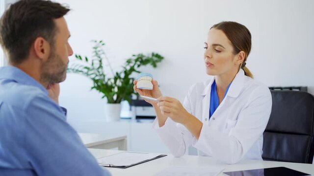 Female dentist talking with patient during consultation