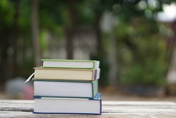 soft focus of the books stacked up on unclear tree background.