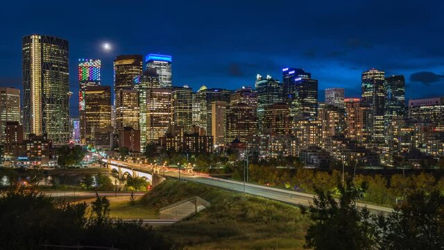Calgary, Alberta, Canada, zoom out time lapse view of Calgary skyline showing landmark buildings in the financial district at dusk.