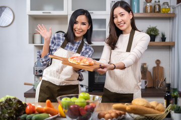 LGBT Lesbian couple love moments cooking Healthy vegetable salad at home.Two young beautiful women girlfriends lesbian couple cook at home in the kitchen cuddling and laughing