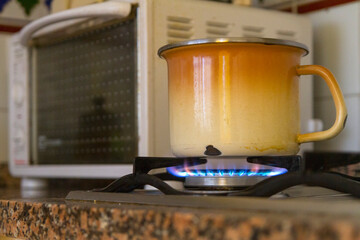 Cazuela u olla calentando comida al fuego de la hornilla y microondas