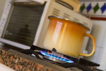 Cazuela u olla calentando comida al fuego de la hornilla y microondas