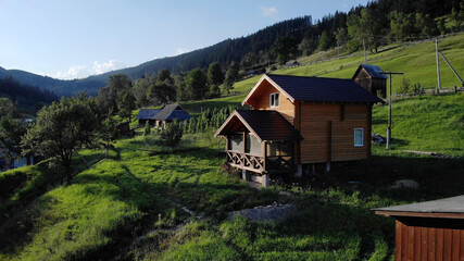 Fototapeta na wymiar Beautiful wooden house for vacation in mountains. Landscape of village in Europe.