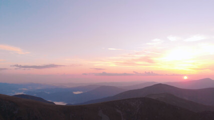 Picturesque multi-colored sky over the mountains. Sunrise in the foggy mountains.