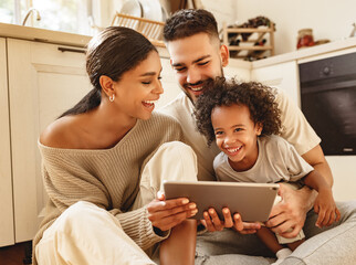 happy multi ethnic family: parents and son laughed and watch funny video on a tablet  at home.