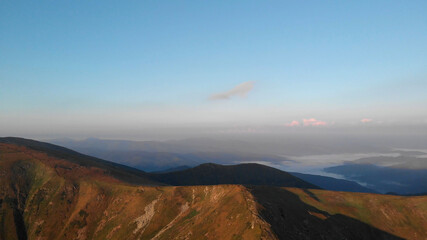 The morning sun illuminates the mountains. Fresh day on the mountain's hills.