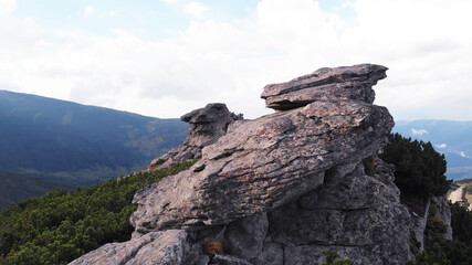 Close view of mountain boulders. Great rocky cliff and majestic mountains on the background.