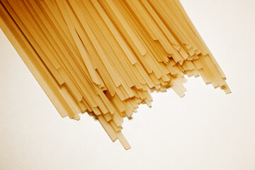 Raw vermicelli pasta background. raw yellow vermicelli is scattered on the table. short raw yellow vermicelli for cooking