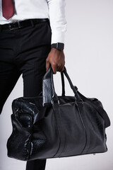 Black businessman man holding a large black business travel bag in his hand