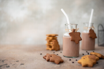 chocolate milkshake in glass bottle with gingerbread crumbly cookies