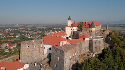 Fototapeta na wymiar Old historical castle on the green hill. Romantic view of medieval fortress. Panorama of city landscape.