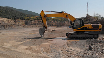Yellow digger machine. Excavator with a shovel for digging. Sand and mud everywhere.