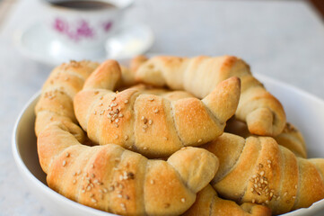 Serbian sesame rolls(kiflice) in the bowl with vintage cup of coffee