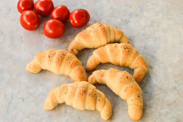 Sesame rolls on the grey background, with tomatoes