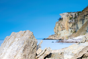 Limestone cliff next to ocean with boulders in foreground
