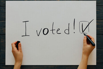 I voted. Female writes political slogan on white paper . Top view
