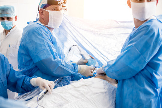The surgeon uses a portable fluorescence imaging device during breast removal.