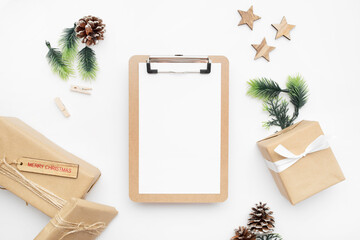 Top view of Christmas composition with gift box, ribbon, fir branches, cones, anise on white background with copy space.