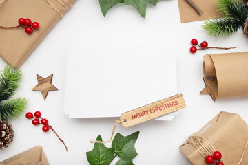 Top view of Christmas composition with gift box, ribbon, fir branches, cones, anise on white background with copy space.