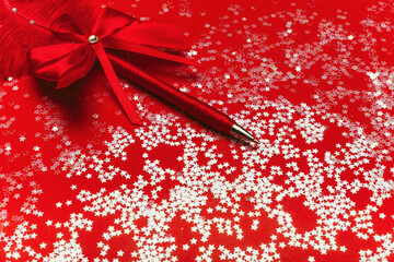 Beautiful pen on a red background with sparkles.