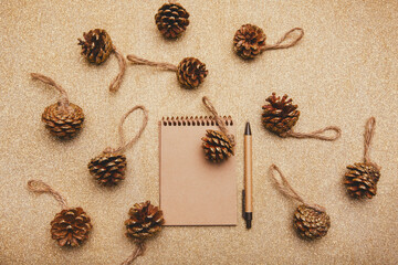 Craft notebook on gold background with cones.