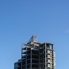 Fototapeta na wymiar Unfinished skyscraper against the blue sky.