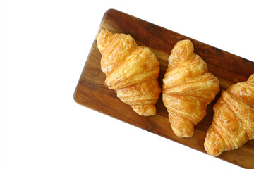 homemade croissants on wooden cutting board isolated on white background, top view