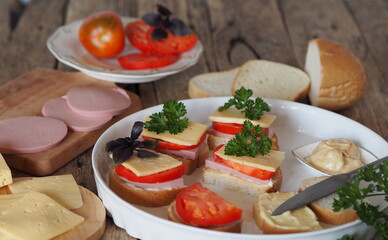 Fresh sandwich with cheese and sausage. Hot sandwiches.Sandwiches with sausage and hard cheese on a wooden background.