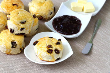 raisin scones with jam and butter on the table 