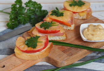 Natural healthy food. Sandwiches on a wooden white plate.Hot homemade sandwiches with sausage, tomatoes and cheese.