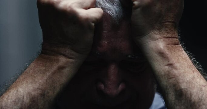 Dramatic depressed older man in agony. 60 year old man suffering mental distress
