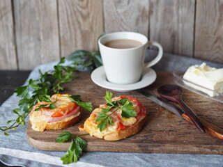 Home cooking.Healthy natural breakfast with hot sandwiches with cheese and tomatoes and a cup of coffee on an ancient ancient background.