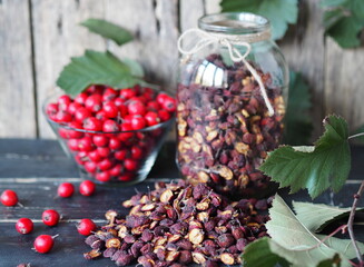Useful properties of hawthorn berries. Fresh and dried hawthorn on a wooden background.Alternative traditional medicine using hawthorn.
