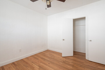 Room interior with closet open and wooden floors