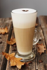 Coffee latte with beans and oak leaves on the table