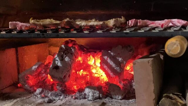 Ribs roasting in a barbecue with fire.